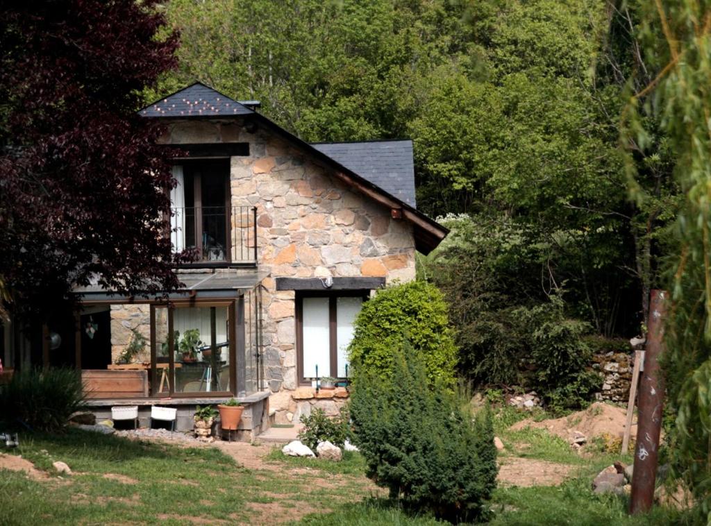 uma casa de pedra com um alpendre e uma varanda em Jardín de Hoz em Hoz de Jaca