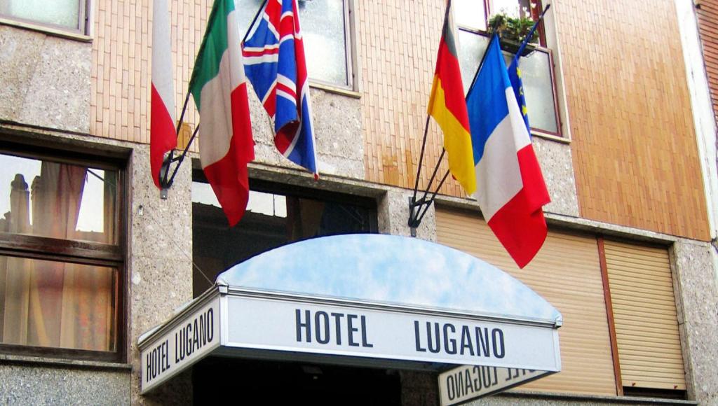 ein Hotel-Luginia mit Flaggen, die von einem Gebäude hängen in der Unterkunft Hotel Lugano in Mailand