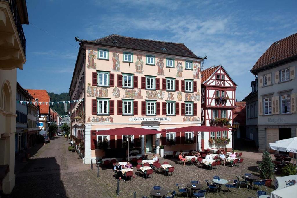 un gran edificio con mesas y sillas delante de él en Hotel Karpfen en Eberbach