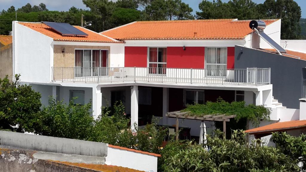 a white and red house with an orange roof at The Wishing Well Country House in São Martinho do Porto