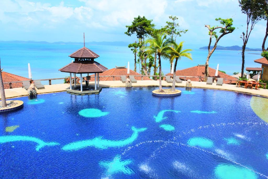 a swimming pool at a resort with fish in the water at Supalai Scenic Bay Resort And Spa, SHA Extra Plus in Por Bay
