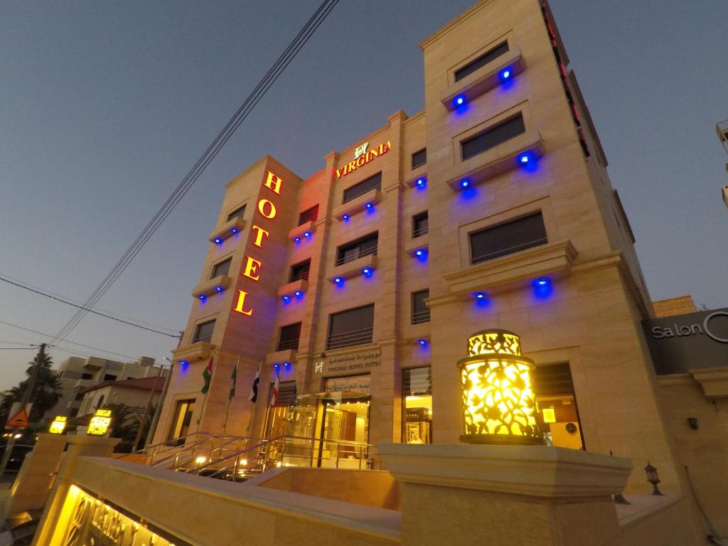 un edificio con luces azules delante de él en Virginia Hotel en Amán