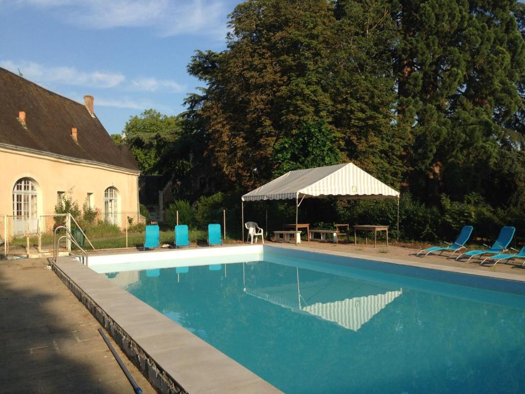- une piscine avec une table, des chaises et une tente dans l'établissement Château de Rys, à Bossay-sur-Claise