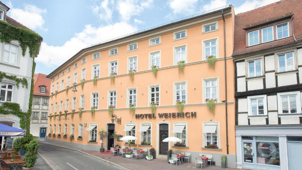 a large orange building on a city street at Hotel Weierich in Bamberg