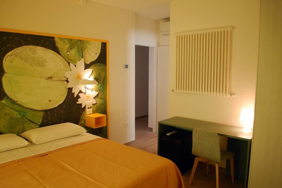 Un dormitorio con una cama y un escritorio con una pintura en B&B Angelo, en Ascoli Piceno