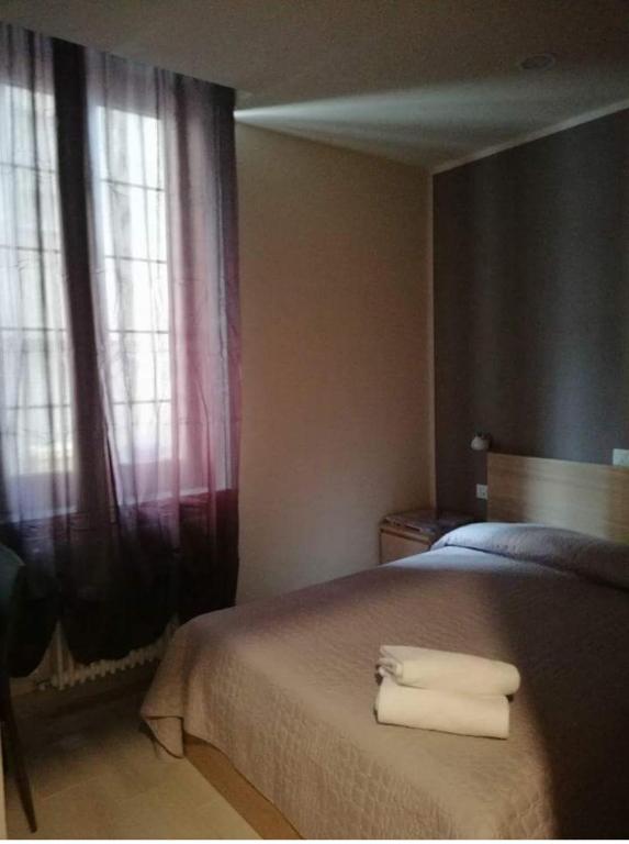 A bed or beds in a room at Albergo Torino