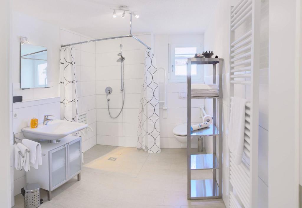 ein weißes Badezimmer mit Dusche und Waschbecken in der Unterkunft Braviscasa - Ferienresidenz Hochfirst Titisee in Titisee-Neustadt