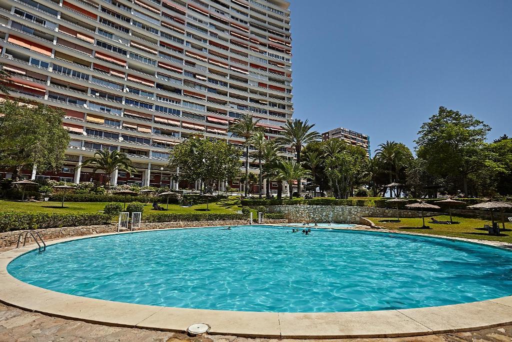 een groot zwembad voor een groot gebouw bij Coqueto Apartmento con vistas al mar in Alicante