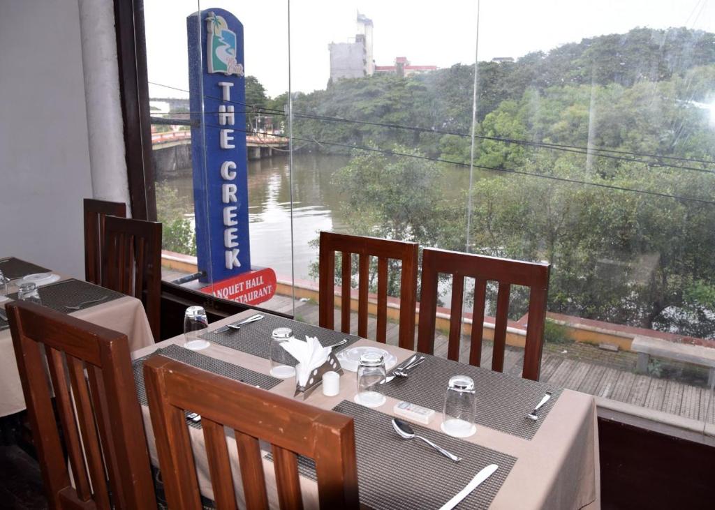 een tafel in een restaurant met uitzicht op een rivier bij Creek Hotel in Panaji