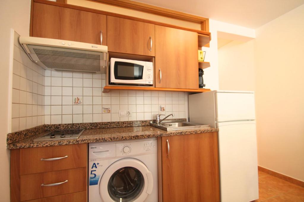 a kitchen with a washing machine and a microwave at Pont de Toneta 3,5 Ransol, Zona Grandvalira in Ransol