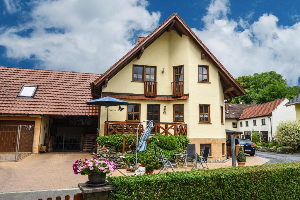 a large yellow house with a roof at Ferienappartement Balik in Bad Staffelstein
