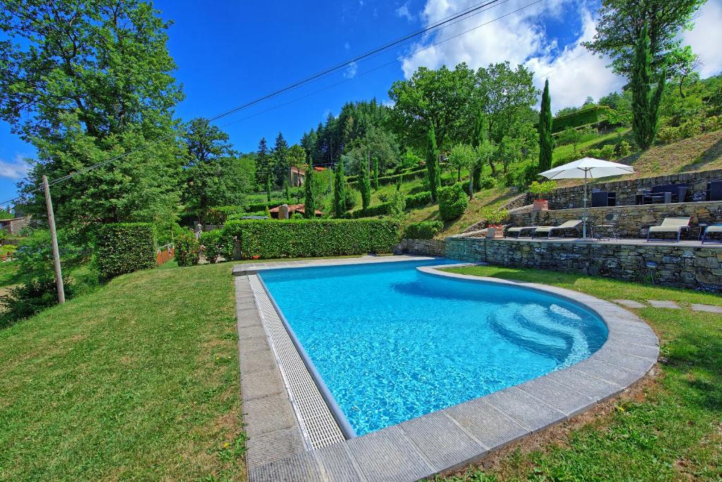een zwembad in de tuin van een huis bij Villa Margherita by PosarelliVillas in Piegaio