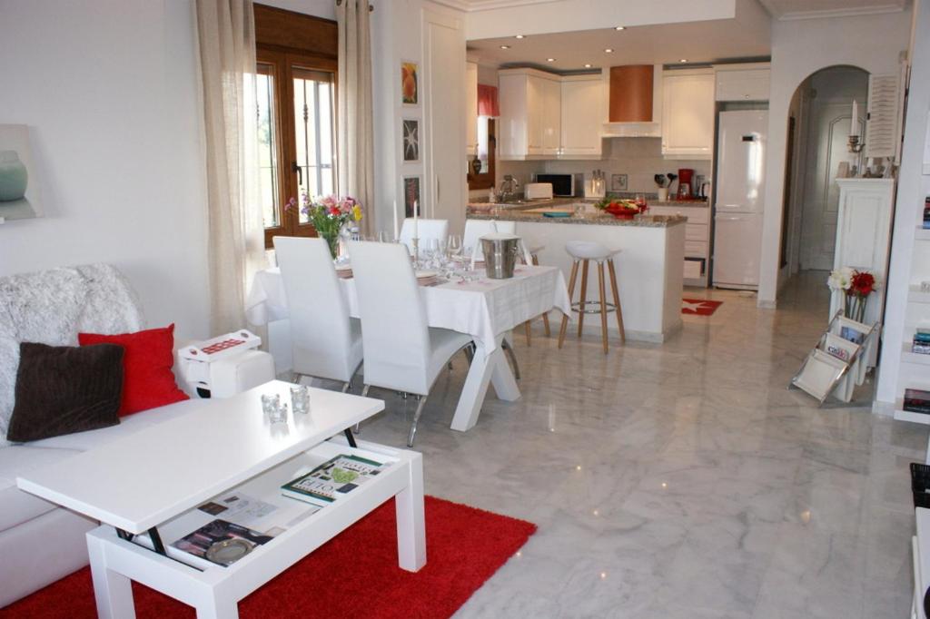 a living room and kitchen with a white table and chairs at Calle Rigoletto Villamartin Costa Blanca in Villamartin
