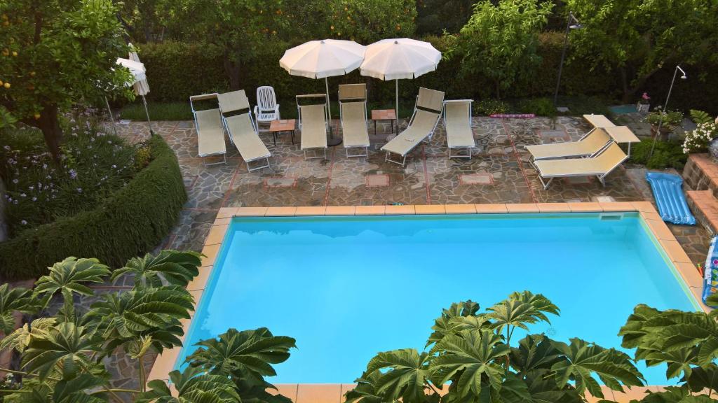 a swimming pool with chairs and umbrellas at Villa Flavia in Sant'Agnello