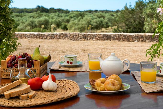 - une table avec petit-déjeuner composé de pain et de jus d'orange dans l'établissement Ca Na Maria Teueta, à San Ferran de Ses Roques