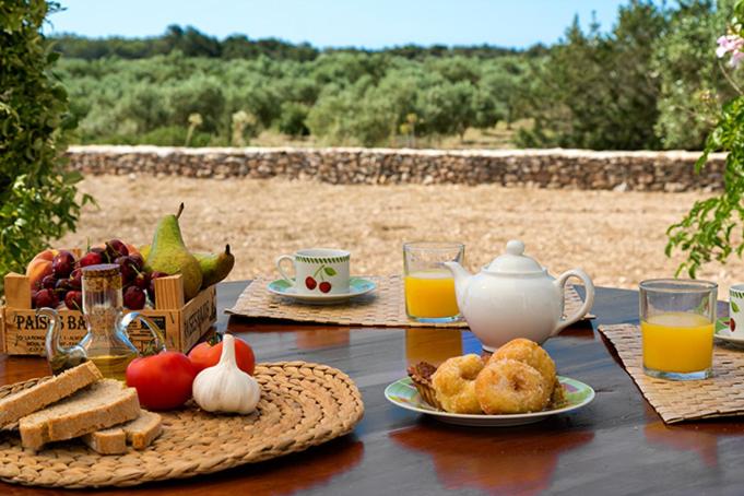 a table with a breakfast of bread and orange juice at Ca Na Maria Teueta in San Ferrán de ses Roques