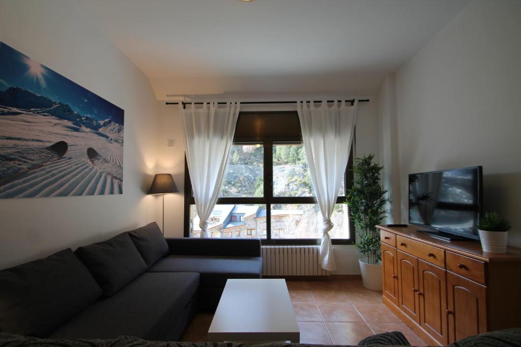 sala de estar con sofá y ventana en Pont de Toneta 4,3 Ransol, Zona Grandvalira, en Ransol