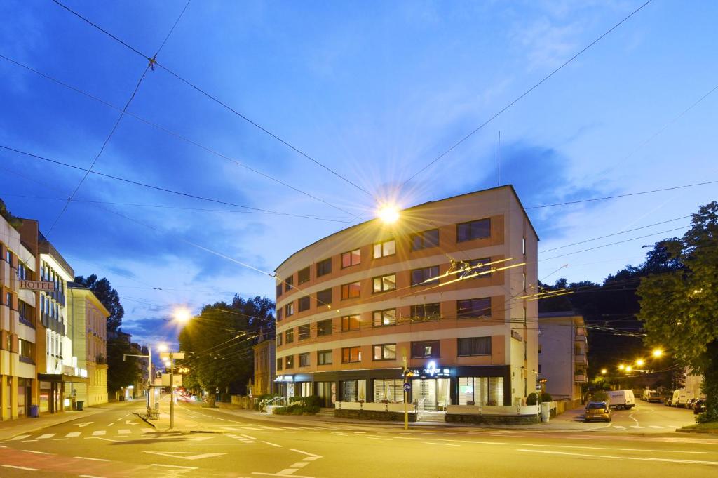 un bâtiment situé dans une rue de la ville la nuit dans l'établissement Am Neutor Hotel Salzburg Zentrum, à Salzbourg