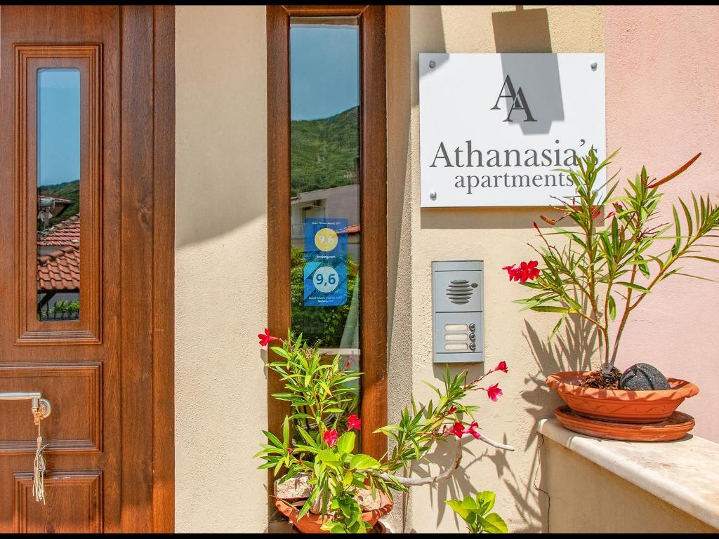 a sign on the side of a building with plants at Athanasia's Apartments in Prinos