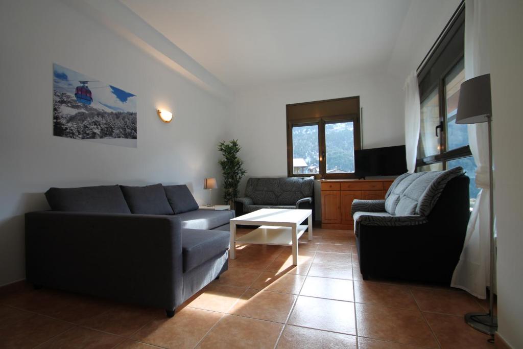 a living room with two couches and a table at Pont de Toneta 4,4 Ransol, Zona Grandvalira in Ransol