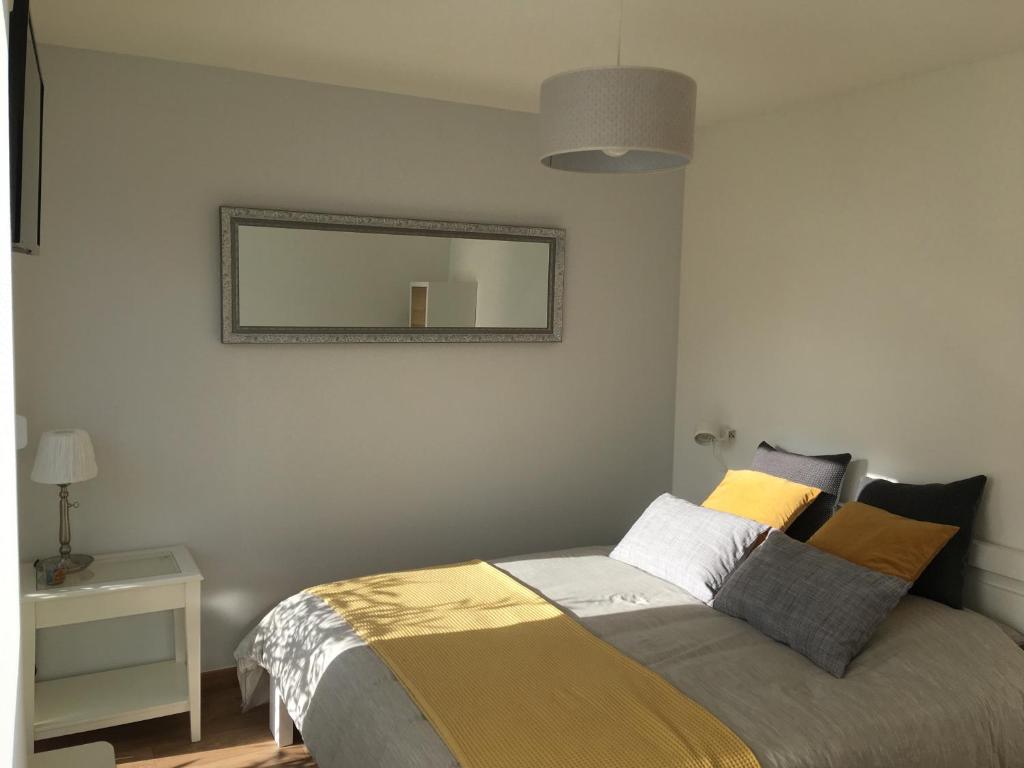 um quarto com uma cama e um espelho na parede em Bienvenus chez nous em Rixheim