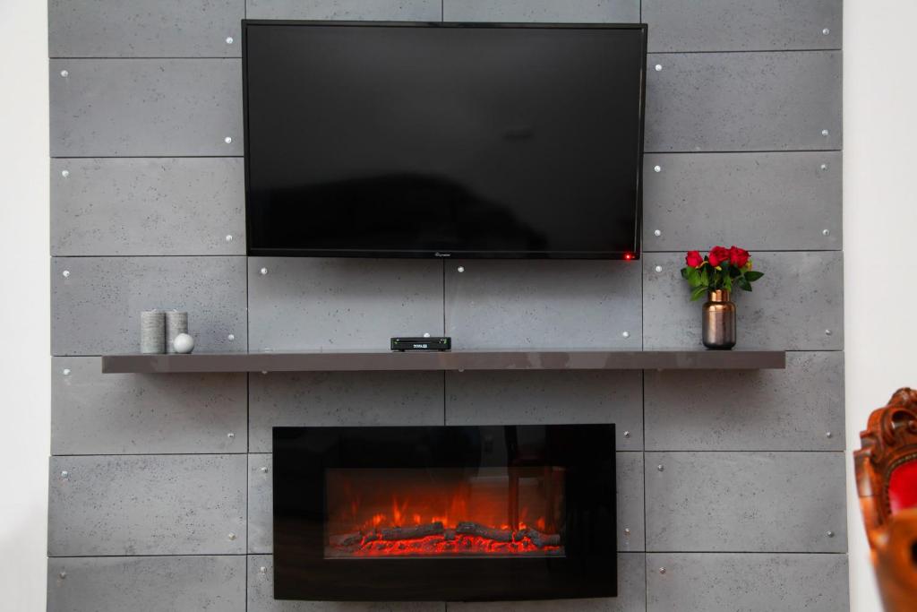 a fireplace with a flat screen tv above it at Apartament EC1 Łódź Fabryczna in Łódź