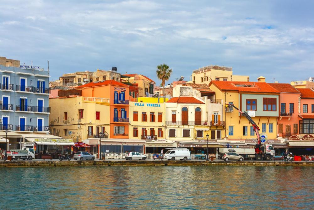 un groupe de bâtiments à côté d'une masse d'eau dans l'établissement Villa Venezia, à La Canée