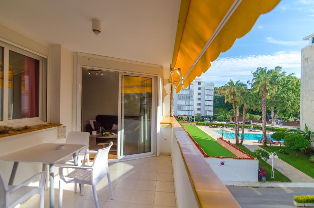 uma varanda com mesa e cadeiras e uma piscina em Park Lein em Lloret de Mar