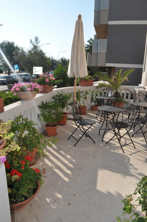 une terrasse avec des chaises, un parasol et des plantes en pot dans l'établissement Villa L'Aurora, à Pescara