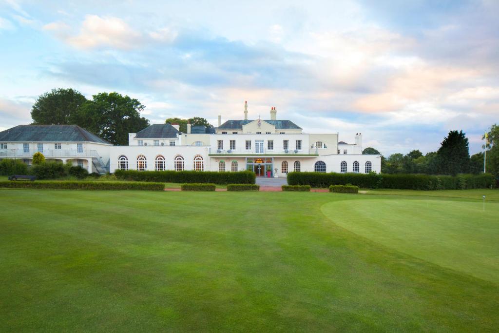 duży biały dom z dużym zielonym trawnikiem w obiekcie Hawkstone Park w mieście Wem