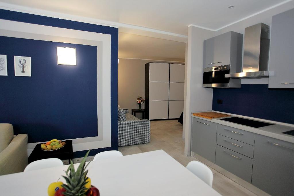een keuken en een woonkamer met een blauwe muur bij Il Convento Case Vacanze in Rapallo