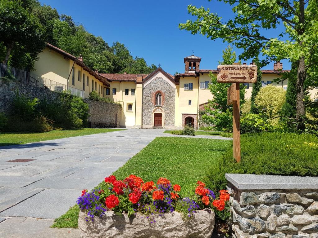 a house with a sign and flowers in front of it at Certosa 1515 in Avigliana