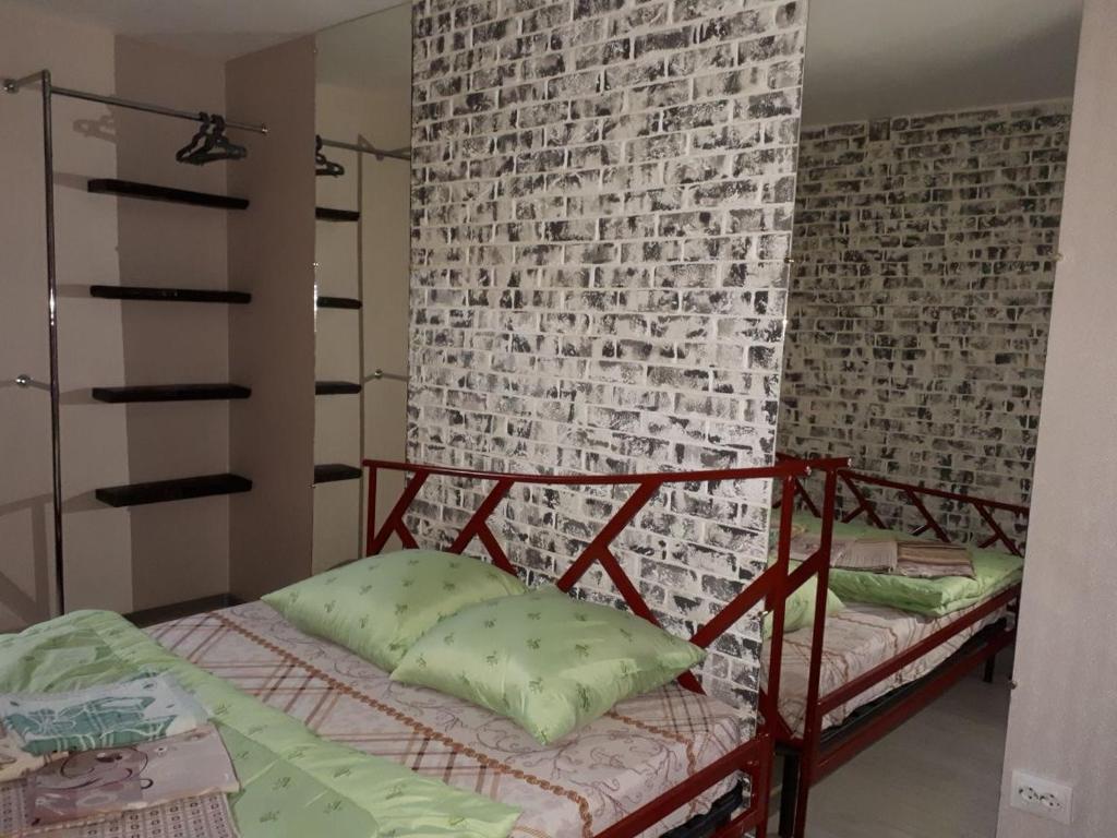 ein Schlafzimmer mit einer Ziegelwand und einem Etagenbett in der Unterkunft Апартаменты двухкомнатные in Kansk