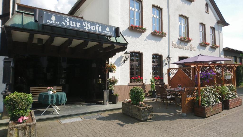 um restaurante com uma mesa em frente a um edifício em Gasthof zur Post em Cobbenrode