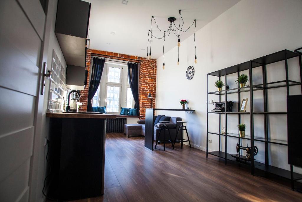 a living room with a kitchen and a dining room at Apartament LOFT Industrial EC1 in Łódź