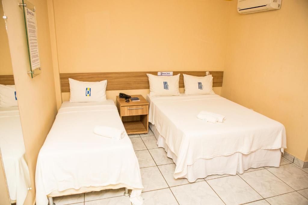 a hotel room with two beds and a desk at Hotel Diniz in Barra do Corda