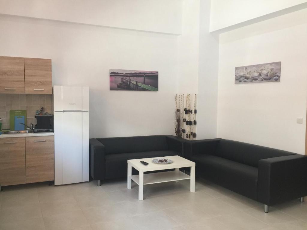 a living room with a black couch and a table at Sisifou Hostel in Korinthos