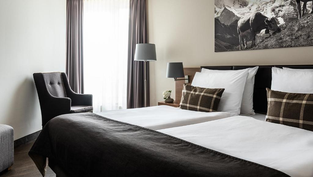 Postel nebo postele na pokoji v ubytování AMERON Luzern Hotel Flora