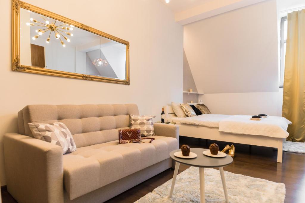 a living room with a couch and a mirror at GoldenEye Apartment Center in Wrocław