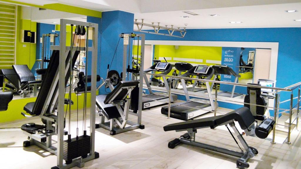a gym with several tread machines in a room at Unirea Hotel & Spa in Iaşi
