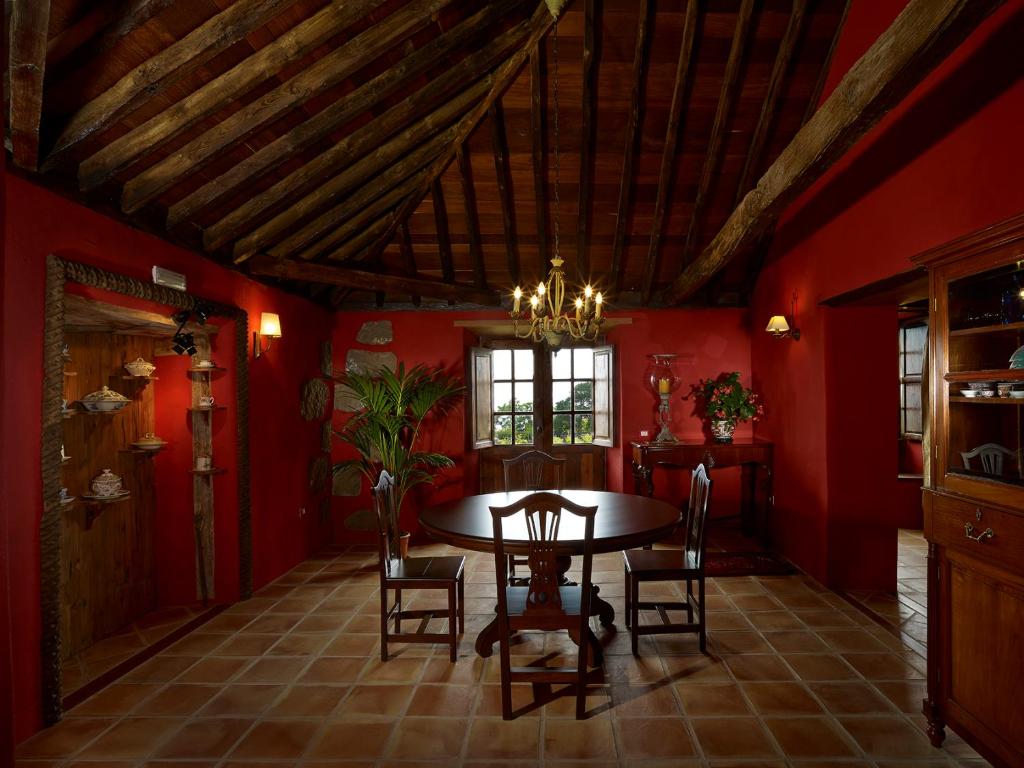 a dining room with red walls and a table and chairs at Haciendas del Valle - Las Kentias in Valle de Guerra