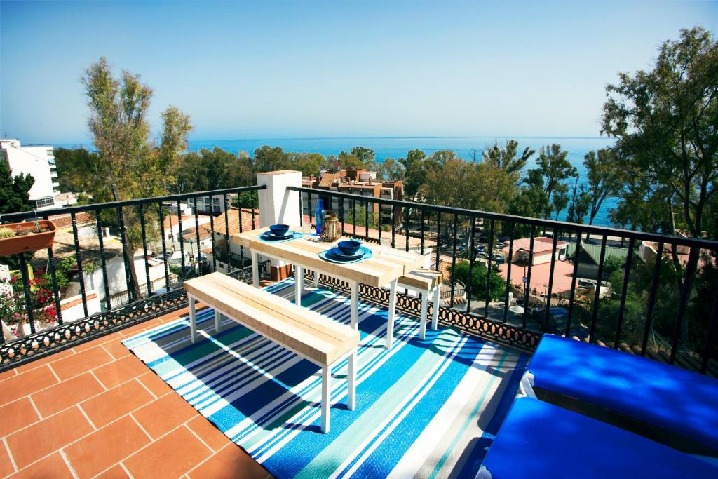 balkon ze stołem i widokiem na ocean w obiekcie PEDREGALEJO SUN & RELAX w Maladze