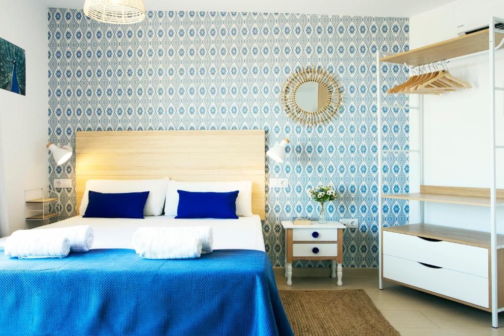 sypialnia z niebieskim łóżkiem z niebieską narzutą w obiekcie PEDREGALEJO SUN & RELAX w Maladze