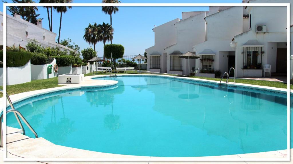 uma grande piscina azul em frente a um edifício em Casa Las Toro Playa em Chilches