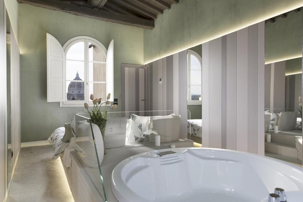 un ampio bagno con vasca e lavandino di Palazzo dei Ciompi Suites a Firenze