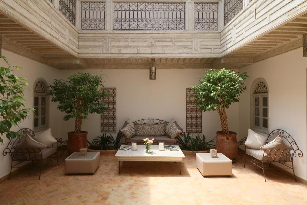 sala de estar con mesa, sillas y árboles en Medina Dream Riad Exclusive Rental, en Marrakech