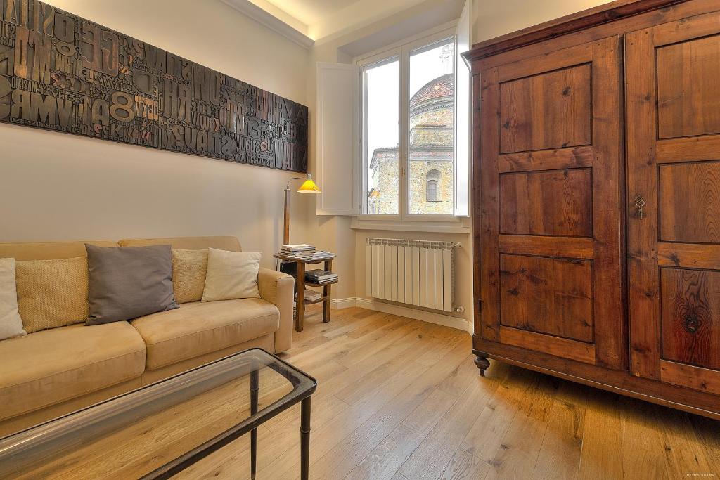 Hotel Medici Chapels, a living room with a couch and a large wooden cabinet at Medici Chapels in Florence