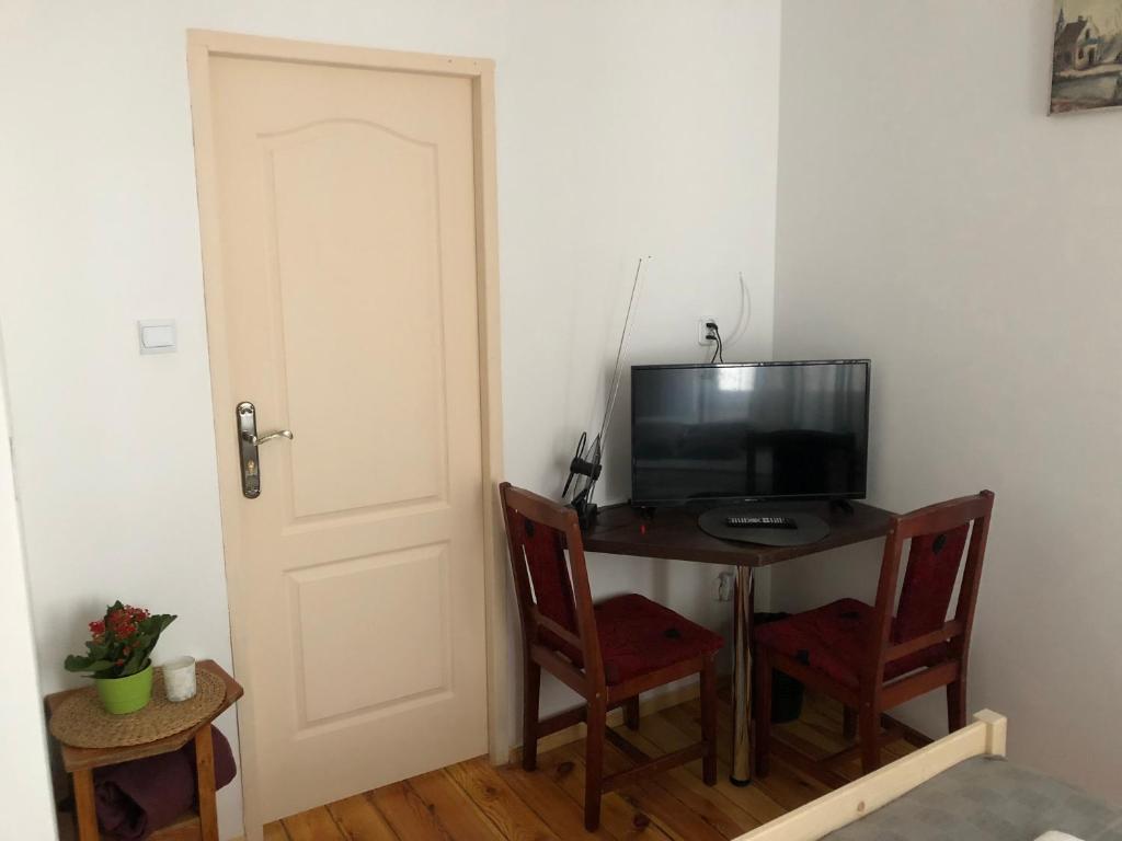 Televízia a/alebo spoločenská miestnosť v ubytovaní Kamienica Centrum