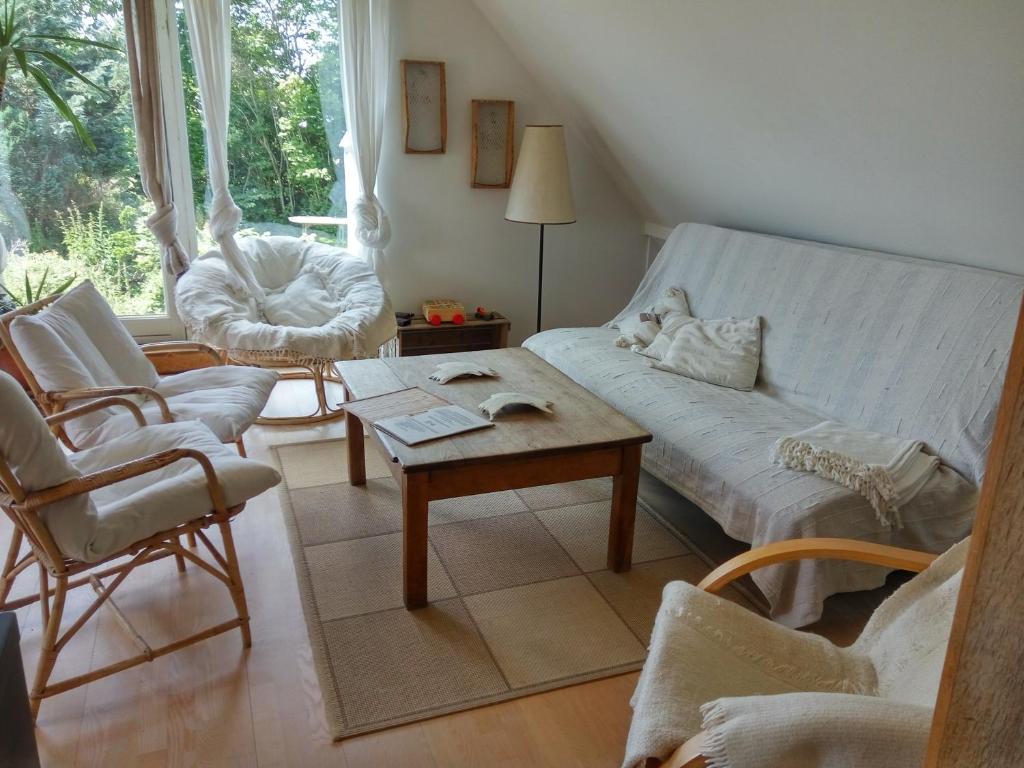 ein Wohnzimmer mit einem Sofa, Stühlen und einem Tisch in der Unterkunft Petersholm in Odder
