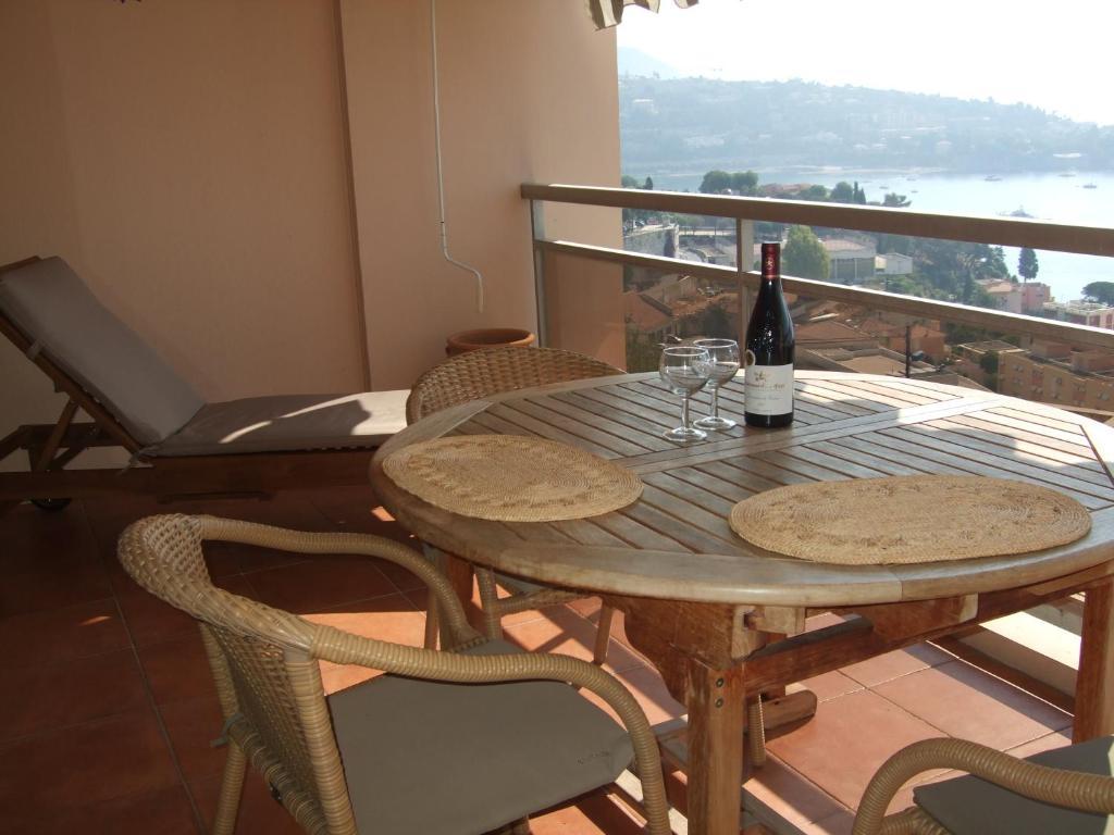 una mesa con una botella de vino y dos copas en L&#39;Agrianthe, en Villefranche-sur-Mer